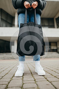 Joyful hipster girl with colored hair, sunglasses and in light summer clothes and looks at the camera with a smile on his face