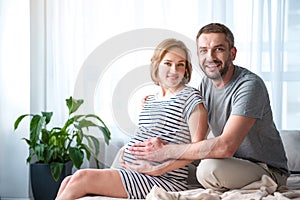 Joyful husband is glad about pregnancy of his wife