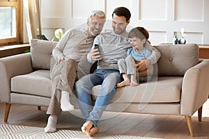 Joyful intergenerational male family taking selfie at home.