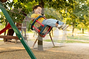 Joyful Japanese Baby Girl Swinging On Swings At Outdoor Playground