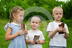 Joyful kids eating chocolate outdoors