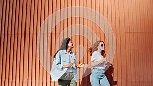 Joyful ladies Asian and Caucasian dancing outdoors having fun laughing