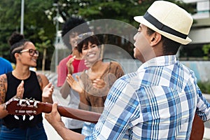 Joyful listening young people at a concert of street muscian