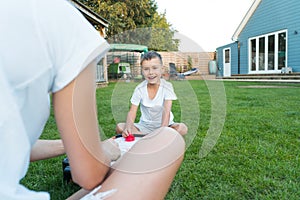 Joyful little boy playing portable air hockey with his mom in the garden. Fun Playing Games in Backyard Lawn on Summer
