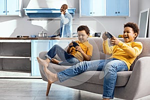 Joyful little boys being immersed into video gaming