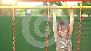 Joyful little girl playing on a swing outdoor