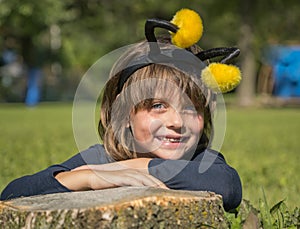 Joyful little girl relaxing on the spring green grass in park