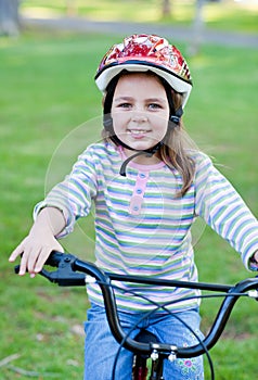 Joyful little girl riding a bike