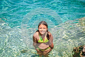 Joyful little girl standing in azure tranquil turquoise amazing Cyprus lake water, at Bruce Peninsula, Ontario