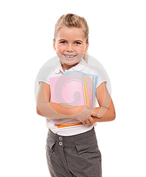 Joyful little girl standing on white with few colorful notebooks