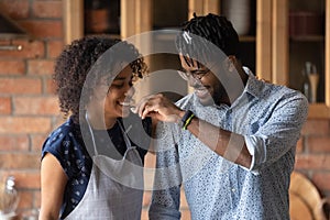 Joyful loving mixed race family couple having fun cooking meal.