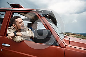 Joyful male friends travelling be off-road car