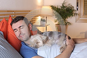 Joyful man in bed with his dog