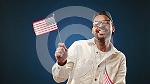 Joyful man dancing with American flags in hands celebrating freedom