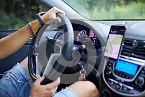 Joyful man driving car, using mobile phone with map gps navigationgoing