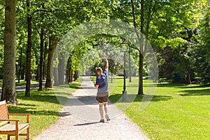 Joyful man jogging in a wooded green spring park