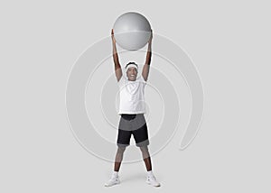 Joyful man lifting exercise ball above his head