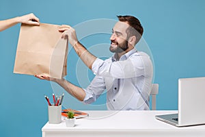 Joyful man in shirt work at desk with pc laptop isolated on blue background. Food products delivery courier service from