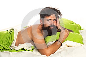 Joyful man sleeping on a bed. Man bearded hipster having problems with sleep. Violations of sleep and wakefulness.
