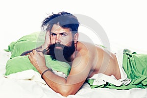 Joyful man sleeping on a bed. Man bearded hipster having problems with sleep. Violations of sleep and wakefulness.