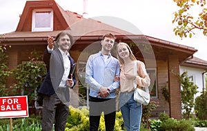 Joyful married couple meeting real estate broker to look at house for sale, outside