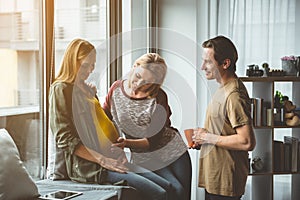 Joyful married couple spending time with surrogate pregnant woman