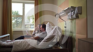 Joyful married couple watching funny video in ward