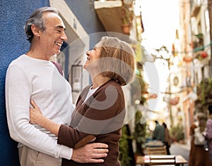 Joyful Mature European Couple Hugging Standing Outside On A Street