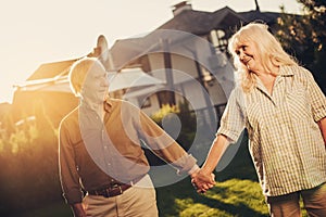 Joyful mature twosome on lawn fronting house