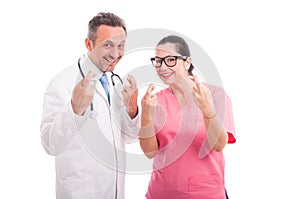 Joyful medical team indicate good luck sign