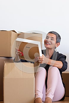 Joyful mid adult woman moving into new apartment