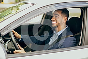 Joyful middle-eastern businessman driving his new auto