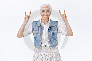 Joyful modern, stylish cool granny, having fun with grandkids listening rock-n-roll music telling good old days at heavy