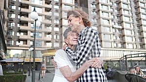 Joyful moment. Family connection. Elderly care. Daughter hugging senior mother. Cuddle concept. Smiling woman and older