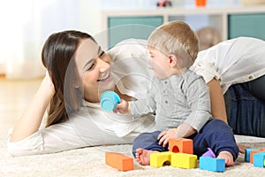 Joyful mother and baby playing on a carpet photo
