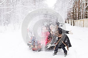 Joyful mother and children enjoy many Christmas presents in car trunk. Snow weather