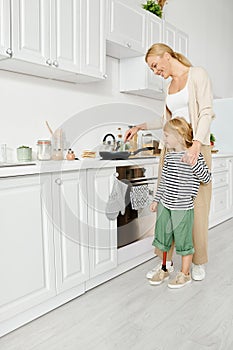 joyful mother cooking and holding hand