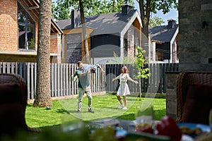 Joyful mother and father are having fun playing with their son