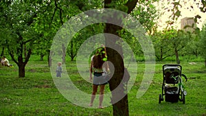 Joyful mother and kids spending time outdoors. Family playing with ball in park