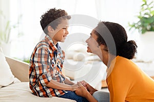 Joyful mother and son engaging in chat talking at home