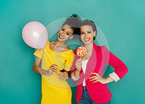 Joyful multiethnic women at turquoise studio background