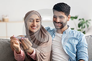 Joyful Muslim Spouses Holding Positive Pregnancy Test Celebrating Result Indoors