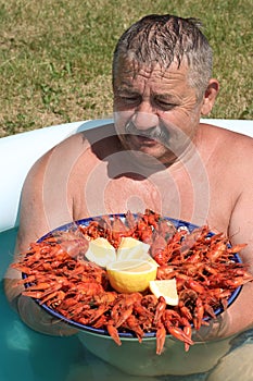 Joyful mustachioed man sits in the pool.