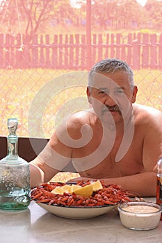 Joyful mustachioed man is sitting at the table.