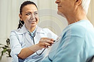 Joyful nice doctor doing medical examination