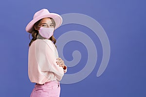 Joyful nice girl posing in protective mask and pink hat