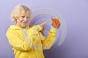 Joyful old lady in yellow sports hoodie prefers healthy eating and active lifestyle.