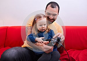 Joyful parent father and sweet cute girl play video game