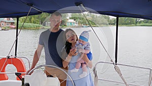 Joyful parents and baby on weekend in background sea, mama, daddy and young child during summer holidays on river