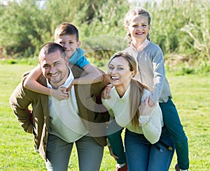 Joyful parents with children outdoor.